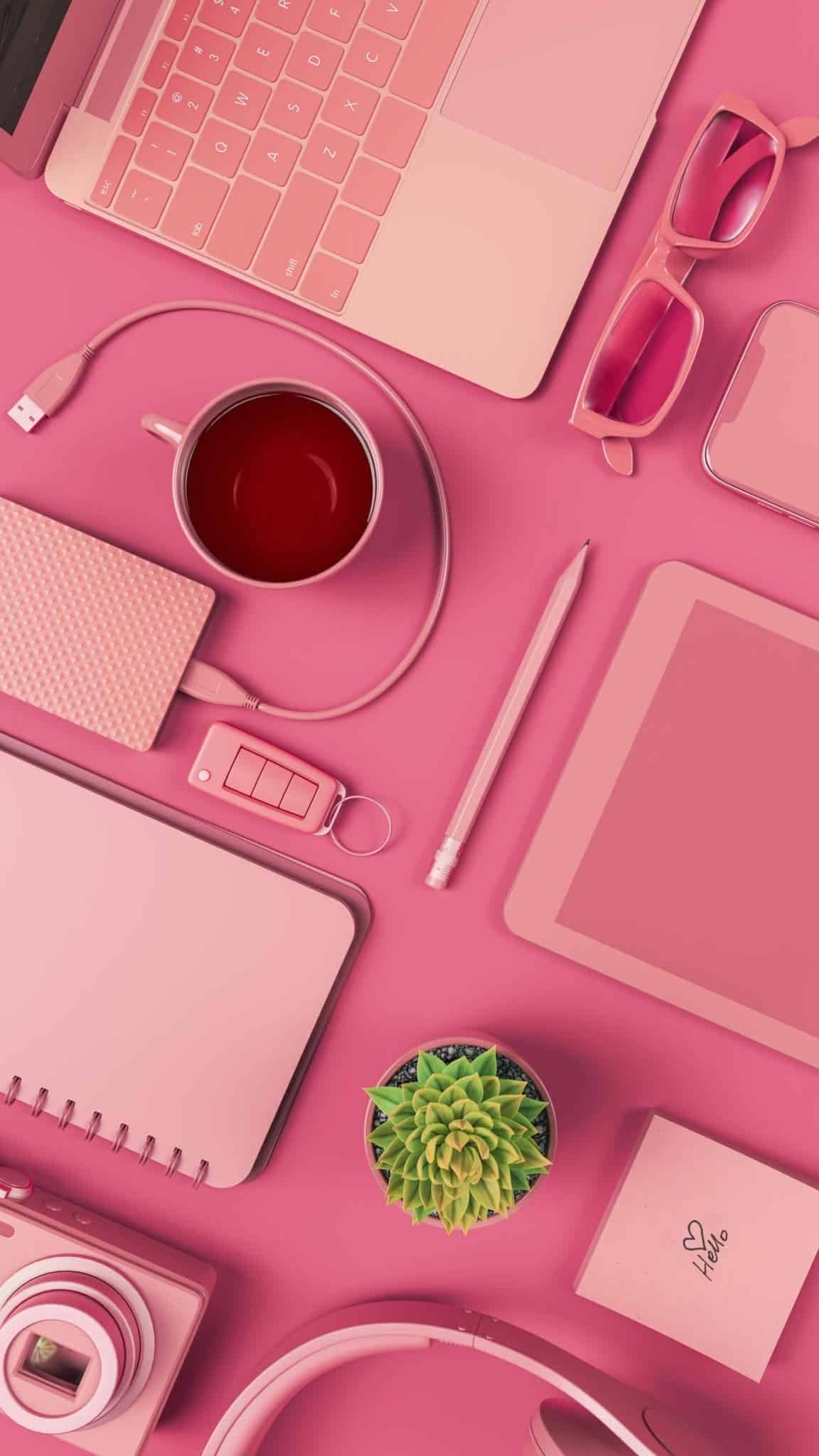 Photo rose d'un bureau avec ordinateur, tablette, carnet, décoration pour le page on discute ?